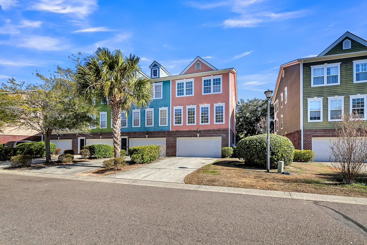 A vibrant neighborhood scene with colorful building facades, a palm tree, and manicured bushes. The scene exudes a cheerful, walkable environment—perfect for evening strolls or exploring nearby local attractions and dining options.